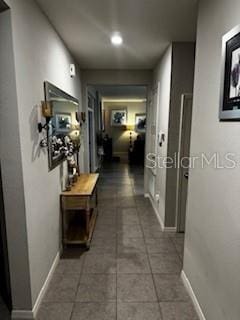 corridor featuring tile patterned floors and baseboards