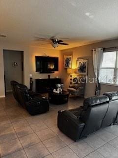 living room featuring a ceiling fan and tile patterned flooring