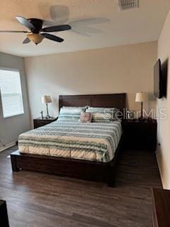 bedroom with visible vents, a ceiling fan, and wood finished floors