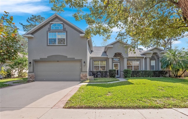 traditional-style home with stucco siding, an attached garage, stone siding, driveway, and a front lawn