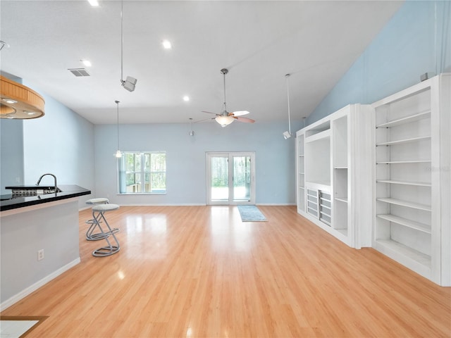 unfurnished living room featuring light wood-type flooring, ceiling fan, visible vents, and baseboards