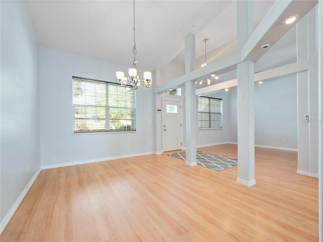 interior space with light wood finished floors, baseboards, and a notable chandelier