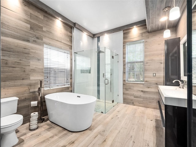 full bath featuring a stall shower, vanity, toilet, and wood finished floors