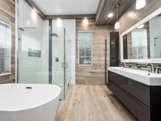 full bathroom with wooden walls, a sink, a soaking tub, a shower stall, and double vanity