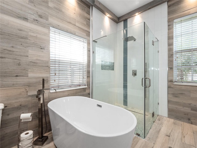 full bathroom featuring a freestanding tub and a shower stall