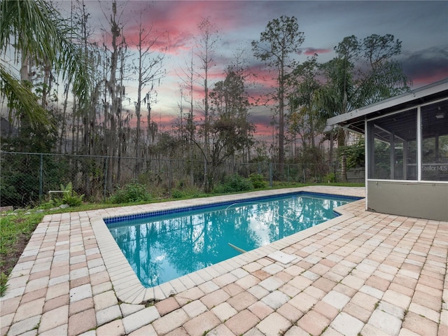 view of swimming pool with a fenced in pool, a sunroom, a fenced backyard, and a patio