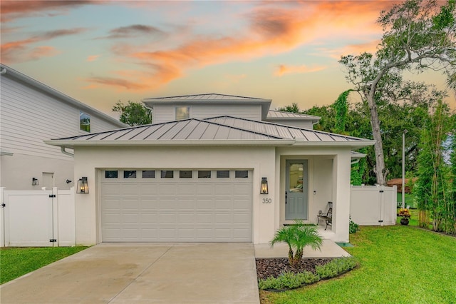 view of front of home featuring a garage, metal roof, a standing seam roof, and a gate