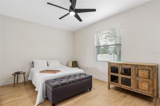 bedroom with light wood-style floors, baseboards, and ceiling fan
