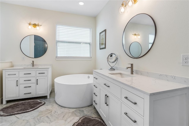 bathroom with a sink, a soaking tub, two vanities, and marble finish floor