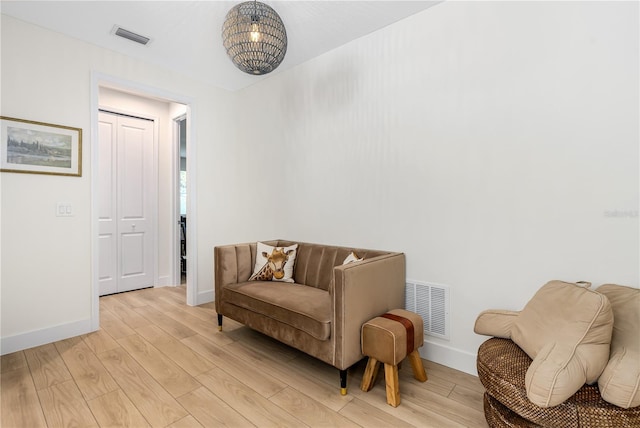 sitting room featuring light wood-style floors, baseboards, and visible vents