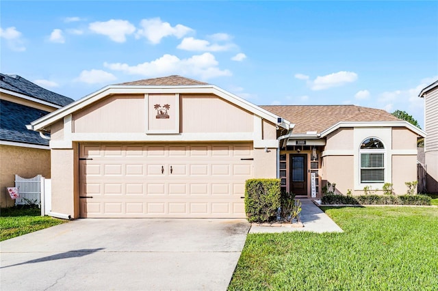 view of front of property with a garage, driveway, a front yard, and stucco siding