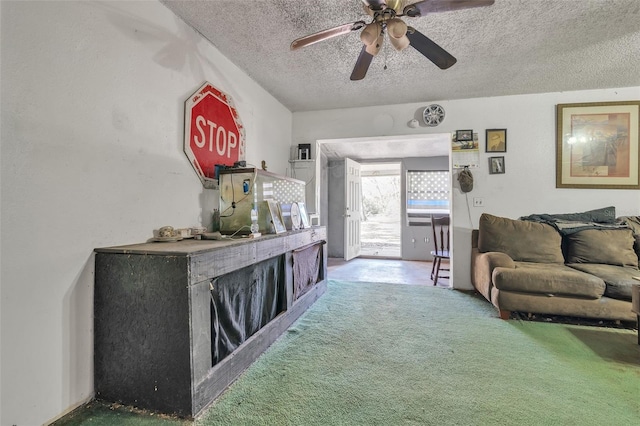 living area with a textured ceiling, carpet, and a ceiling fan