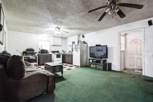 living area with a textured ceiling, carpet floors, and a ceiling fan