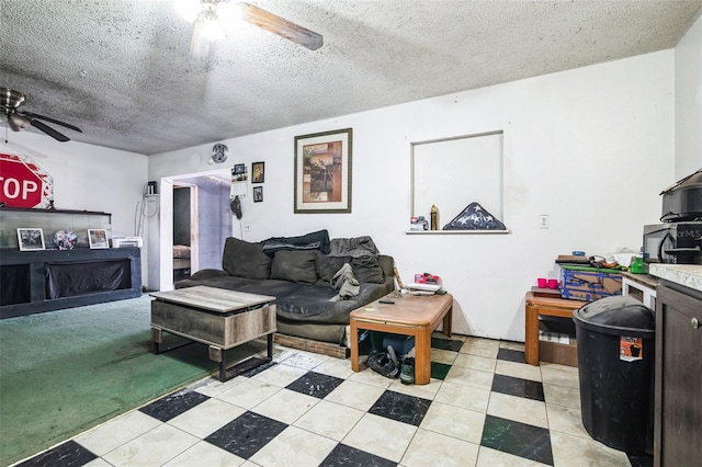 living area with a ceiling fan and a textured ceiling