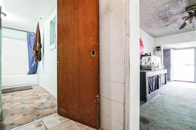 corridor with carpet and a textured ceiling