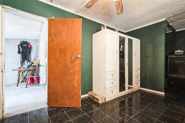 bedroom featuring ceiling fan, baseboards, a textured ceiling, and ornamental molding