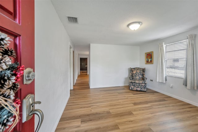 sitting room featuring light wood-style floors, baseboards, and visible vents