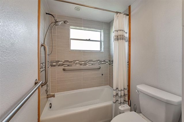 full bathroom featuring a textured wall, shower / bath combination with curtain, and toilet