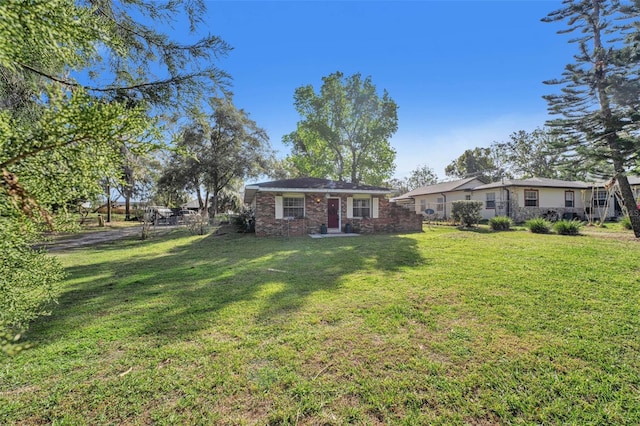 exterior space with brick siding and a front yard