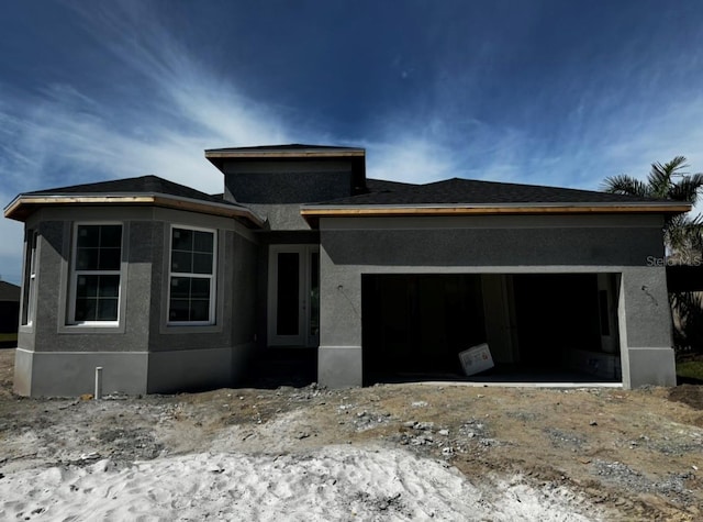 view of front of home with stucco siding and a garage