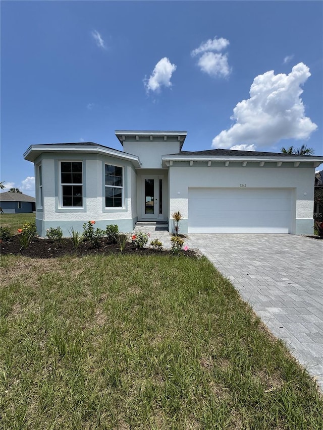 7343 N Ficus Tree, Punta Gorda, FL 33955 - view of front of house with stucco siding, an attached garage, decorative driveway, and a front yard