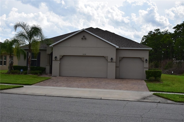 view of front of house featuring decorative driveway, roof with shingles, an attached garage, and stucco siding