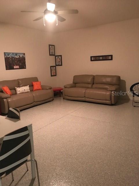 living room featuring a ceiling fan and speckled floor