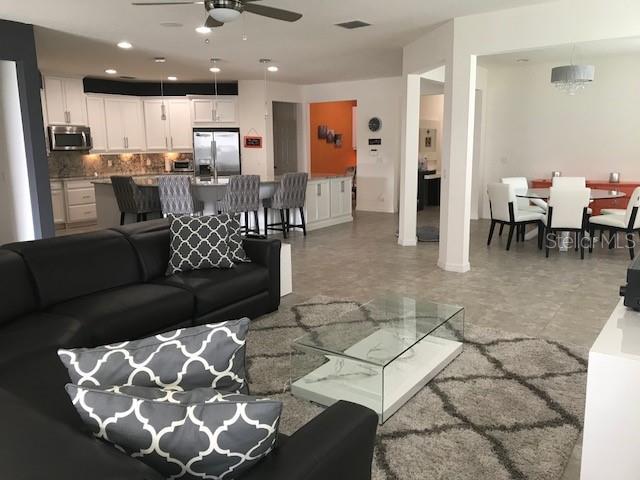 living room featuring a ceiling fan and recessed lighting