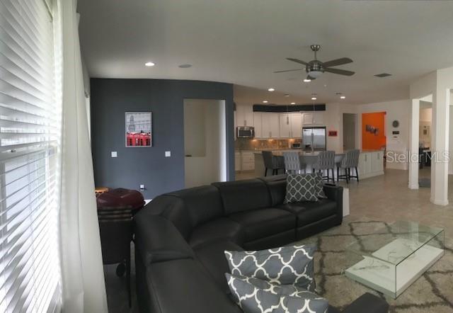 living room featuring a ceiling fan and recessed lighting