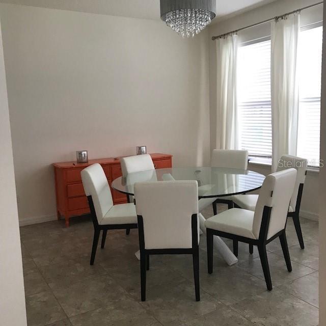 dining area featuring a chandelier, a healthy amount of sunlight, and baseboards