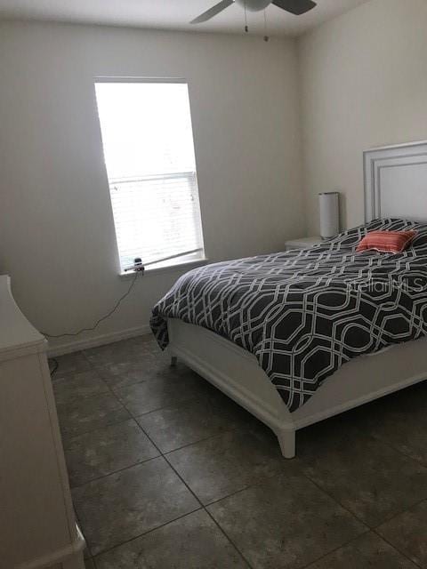 bedroom featuring tile patterned flooring, baseboards, and a ceiling fan