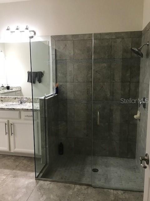 bathroom featuring tile patterned floors, a shower stall, and vanity