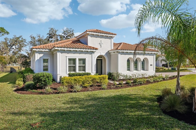 view of front of property with stucco siding, a front lawn, and a tiled roof