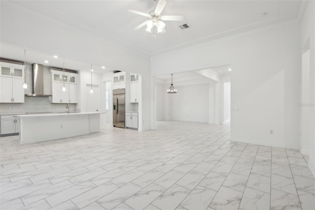 kitchen with built in fridge, visible vents, open floor plan, marble finish floor, and wall chimney exhaust hood