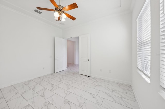 unfurnished room with ceiling fan, marble finish floor, ornamental molding, and baseboards