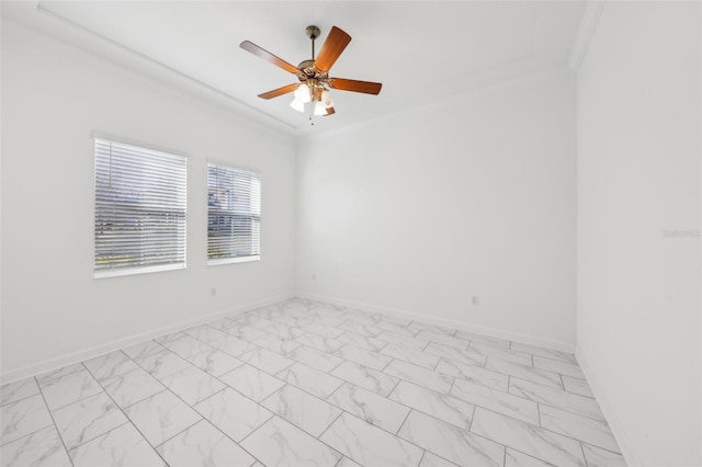 empty room with marble finish floor, baseboards, a ceiling fan, and ornamental molding