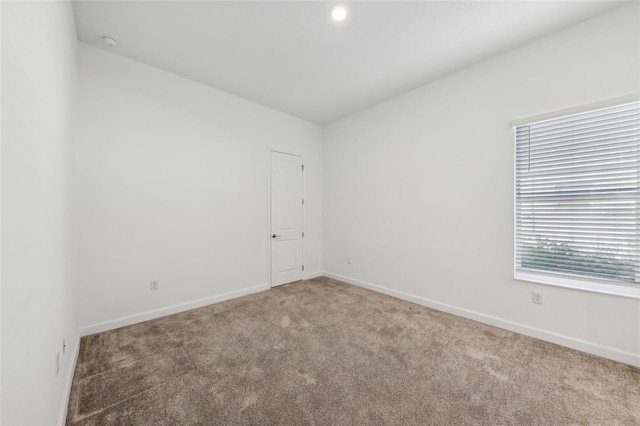 carpeted empty room featuring baseboards