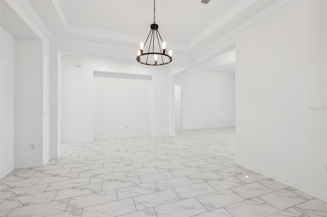 empty room with a chandelier, marble finish floor, ornamental molding, and a raised ceiling