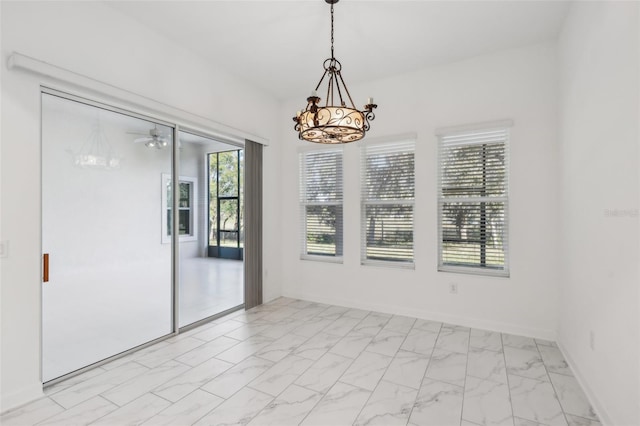 unfurnished room featuring marble finish floor, baseboards, and an inviting chandelier