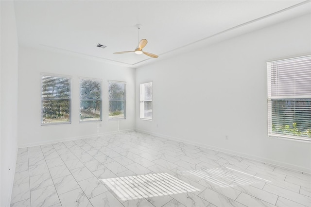 unfurnished room with ceiling fan, marble finish floor, visible vents, and baseboards