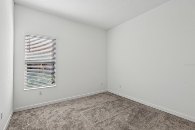 unfurnished room with carpet floors and baseboards