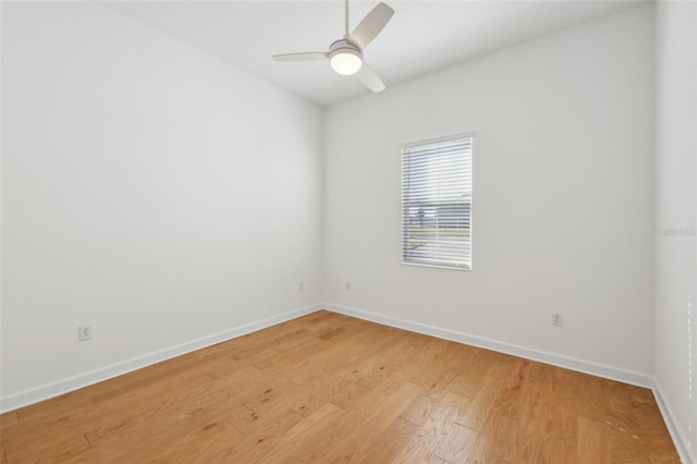 empty room with ceiling fan, light wood-style flooring, and baseboards