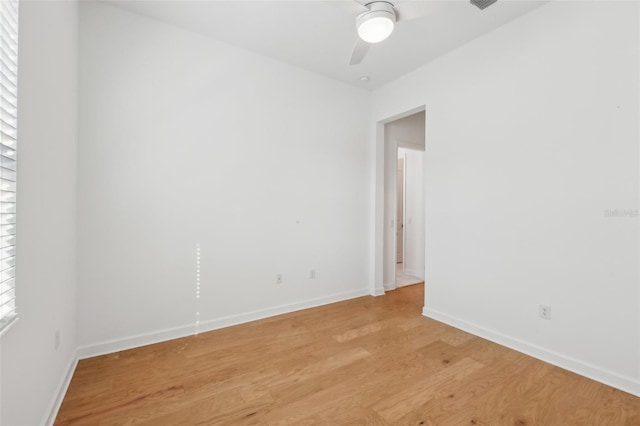 spare room with ceiling fan, a healthy amount of sunlight, light wood-style flooring, and baseboards