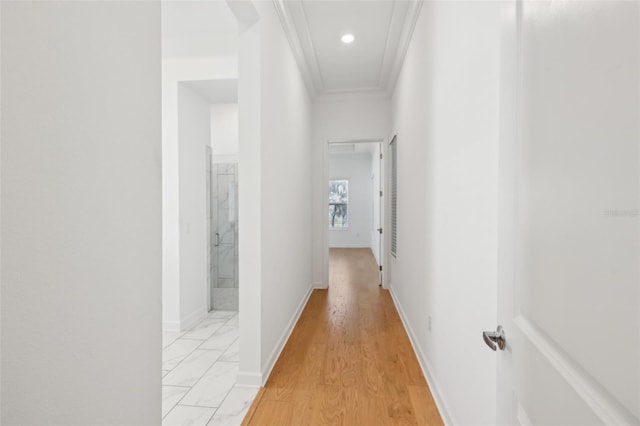 corridor featuring light wood-style floors, baseboards, ornamental molding, and recessed lighting