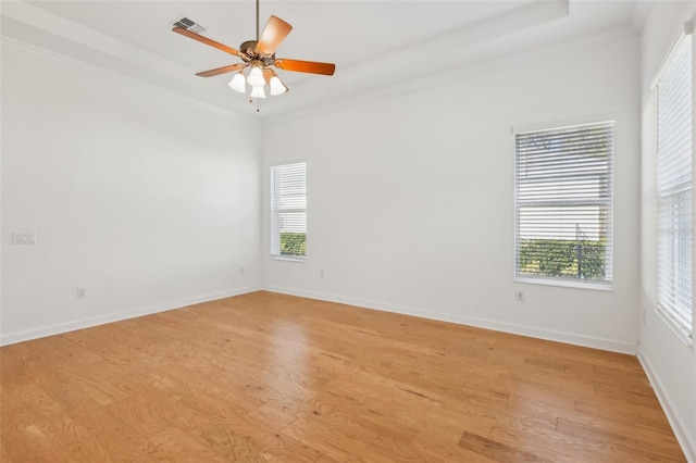 empty room featuring ornamental molding, light wood-type flooring, and visible vents