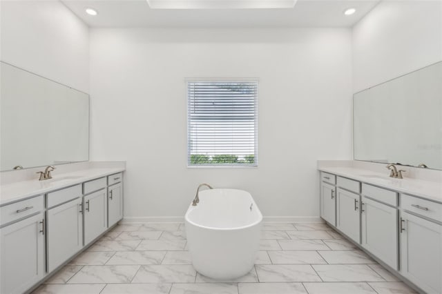 bathroom with marble finish floor, two vanities, and a sink