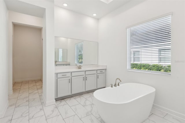 full bathroom with a freestanding bath, marble finish floor, vanity, and recessed lighting