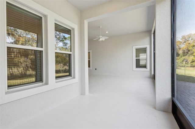 unfurnished sunroom with ceiling fan