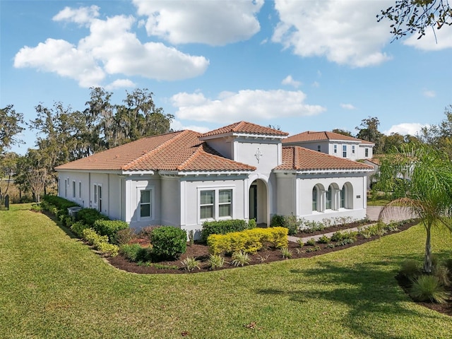 rear view of property with a yard, a tiled roof, and stucco siding