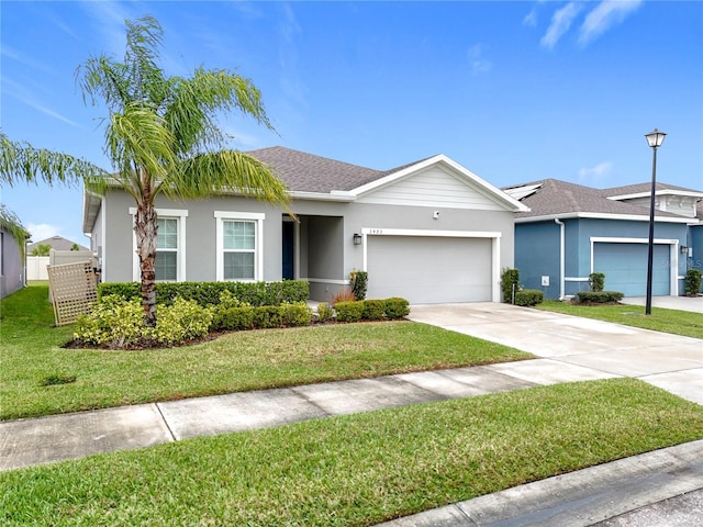 ranch-style home featuring an attached garage, a shingled roof, driveway, stucco siding, and a front lawn